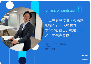 ランスタッド安野さんの写真。青い背景に濃紺のスーツの男性。