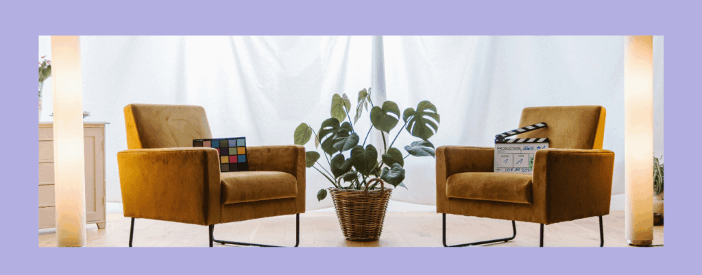 紫の背景、茶色の椅子2脚。中央にモンステラの鉢が置いてある絵。